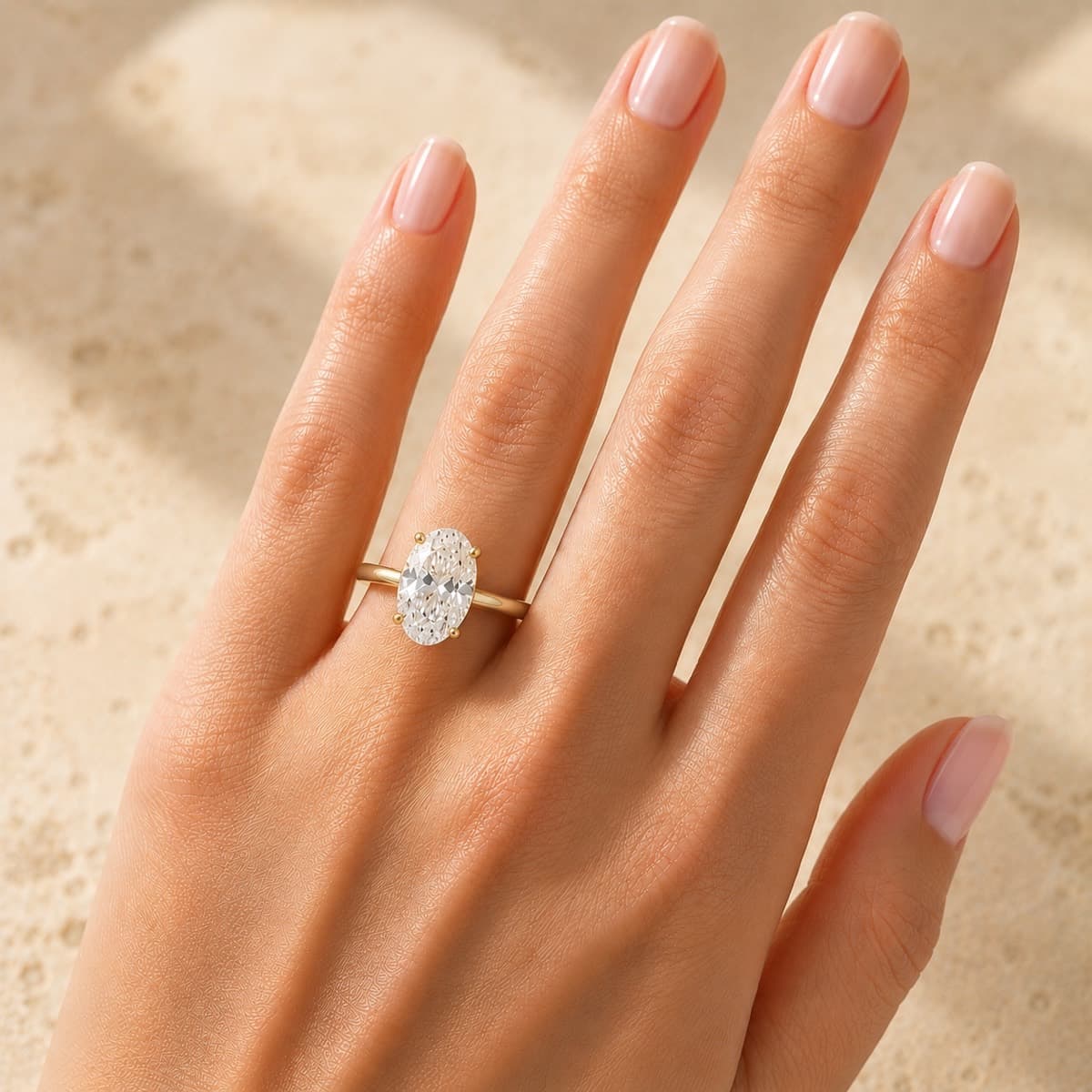 An oval solitaire engagement ring worn on the hand