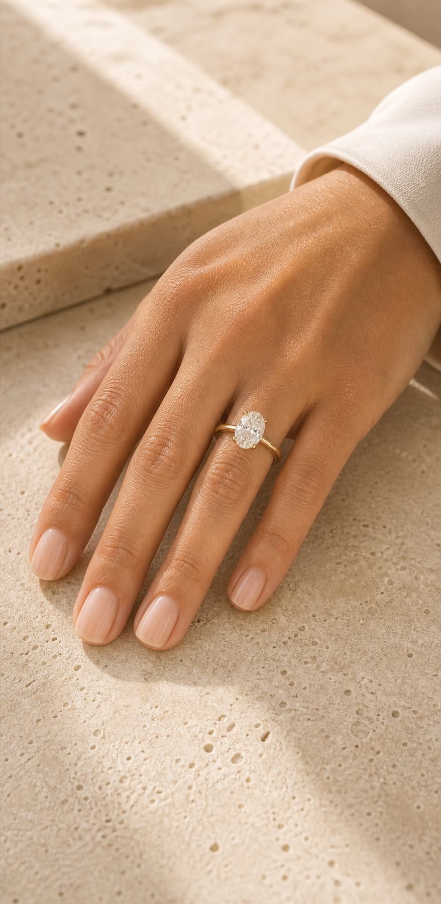 Close-up custom engagement ring on a woman's left hand ring finger in a private jeweler's studio