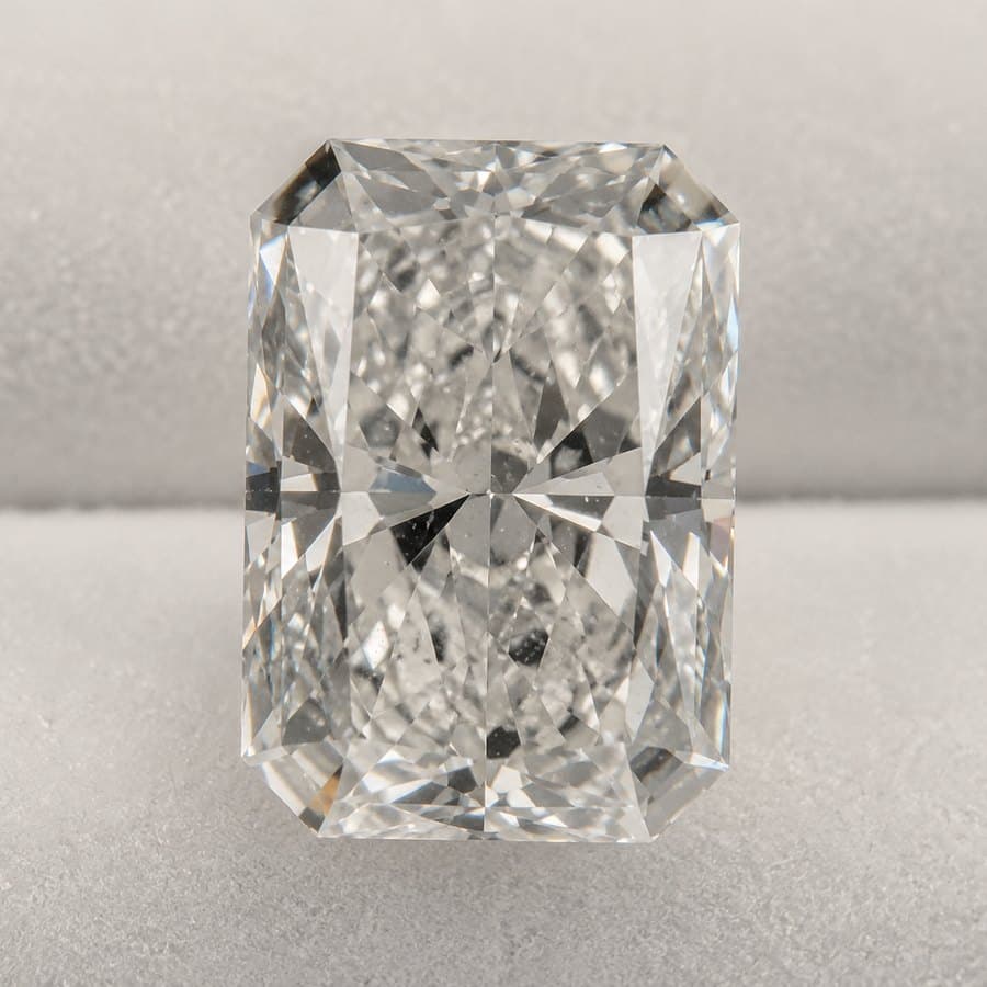 A loose radiant-cut diamond photographed against plain grey, the way online sellers list a stone